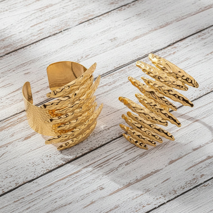 Matching hammered gold statement cuff bracelet and oversized sculptural Ring displayed together as a coordinated jewelry set.