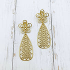 Luxury floral gold teardrop earrings photographed on a white background, featuring intricate African-inspired filigree detailing.