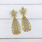 Pair of 18K gold-plated floral statement earrings displayed flat, highlighting detailed filigree craftsmanship and hollow geometric design.