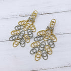 Two-tone gold and silver hollow African-inspired filigree statement earrings with lightweight open geometric detailing.