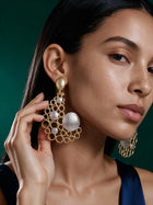 Front product display of oversized gold bubble earrings on a jewelry stand showing the intricate open-circle pattern.