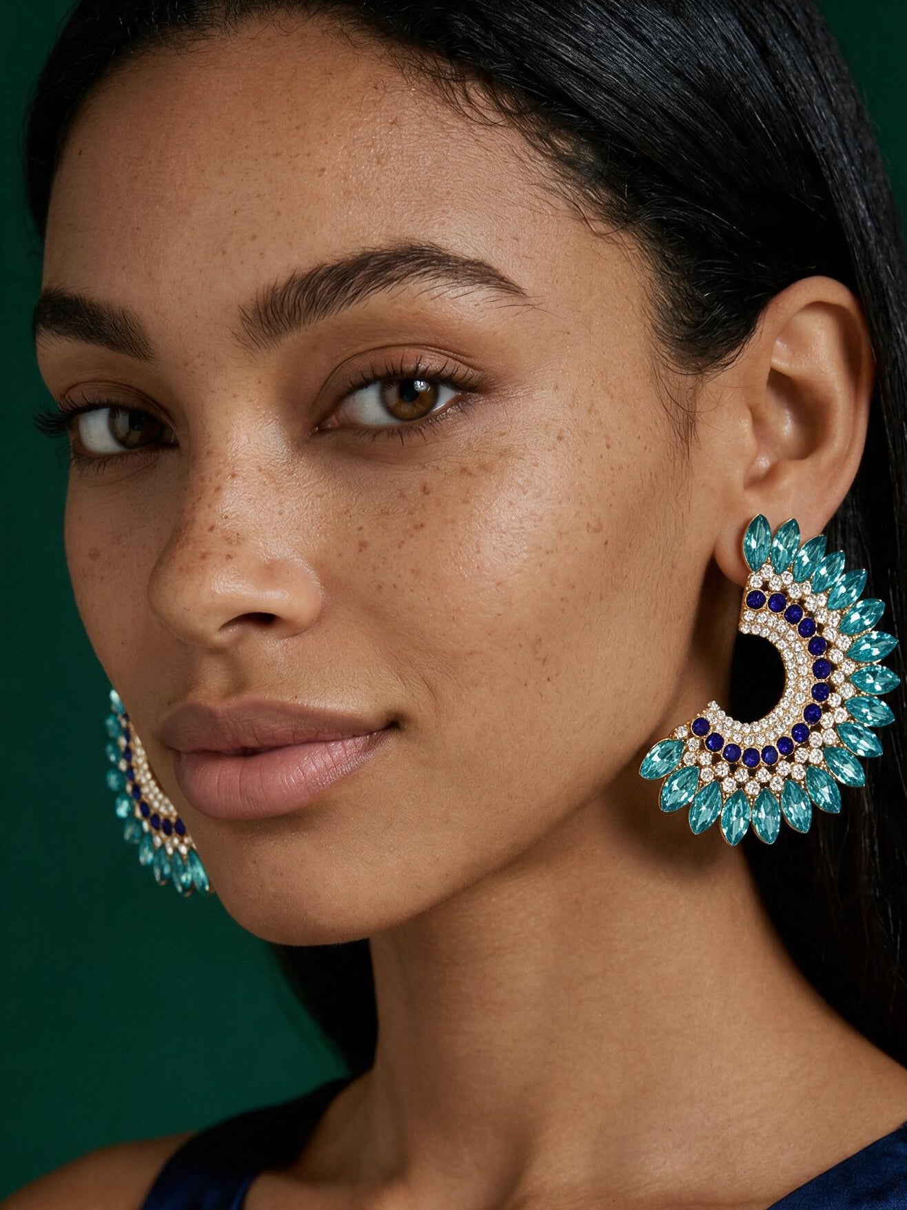Luxury oversized gold crystal statement hoop stud earrings worn by model with braided hairstyle, glamorous rhinestone wedding guest jewelry.