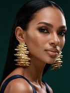 Front portrait of a model wearing bold 18K gold-plated sculptural earrings inspired by African artistry and modern luxury fashion.