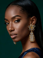 Close-up of lightweight gold filigree statement earrings with floral stud detailing and modern Afro-luxe styling.