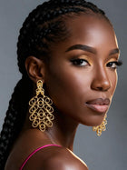 Side profile of a model wearing oversized 18K gold plated African brass filigree earrings with an elegant hollow statement design.