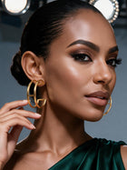 Close-up of a woman wearing minimalist gold round hoop earrings with a sculptural open design, perfect for everyday wear, workwear, vacations, and elegant styling.