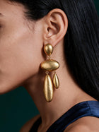 Close-up portrait showcasing lightweight gold waterdrop drop earrings with elongated sculptural silhouette and elegant movement.