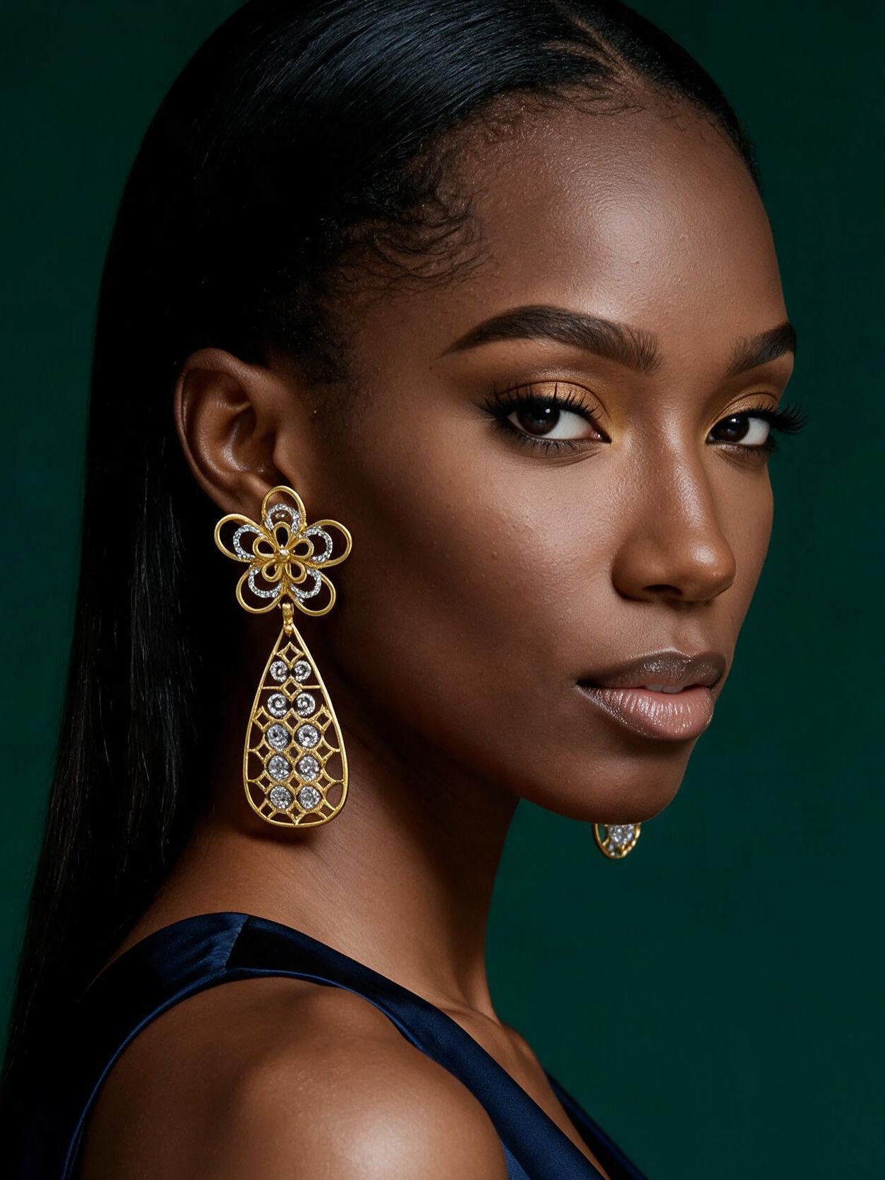 Side profile showcasing elegant African-inspired gold drop earrings with intricate openwork teardrop silhouette.