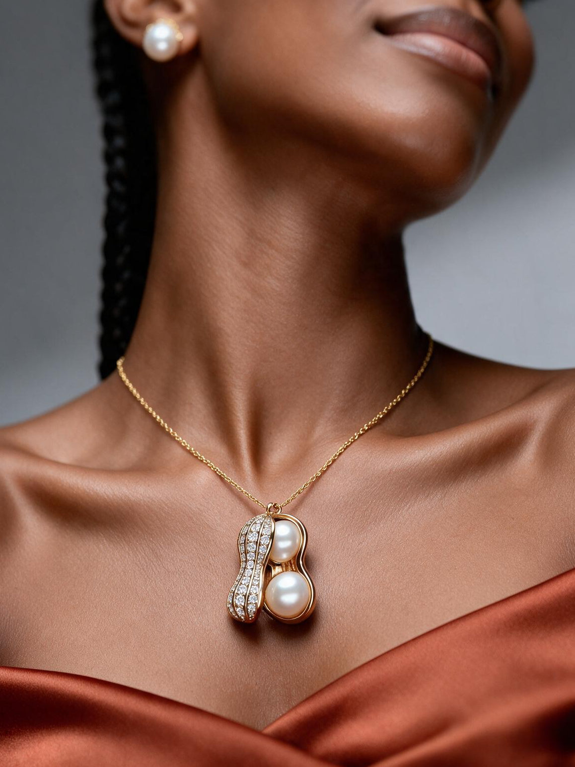 Model wearing an 18K gold plated pearl peanut pendant necklace with ivory pearls and moissanite detailing, styled with matching pearl stud earrings for an elegant luxury look