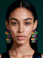 Luxury New Orleans-inspired floral earrings styled with an emerald satin outfit, showcasing colorful botanical statement jewelry.