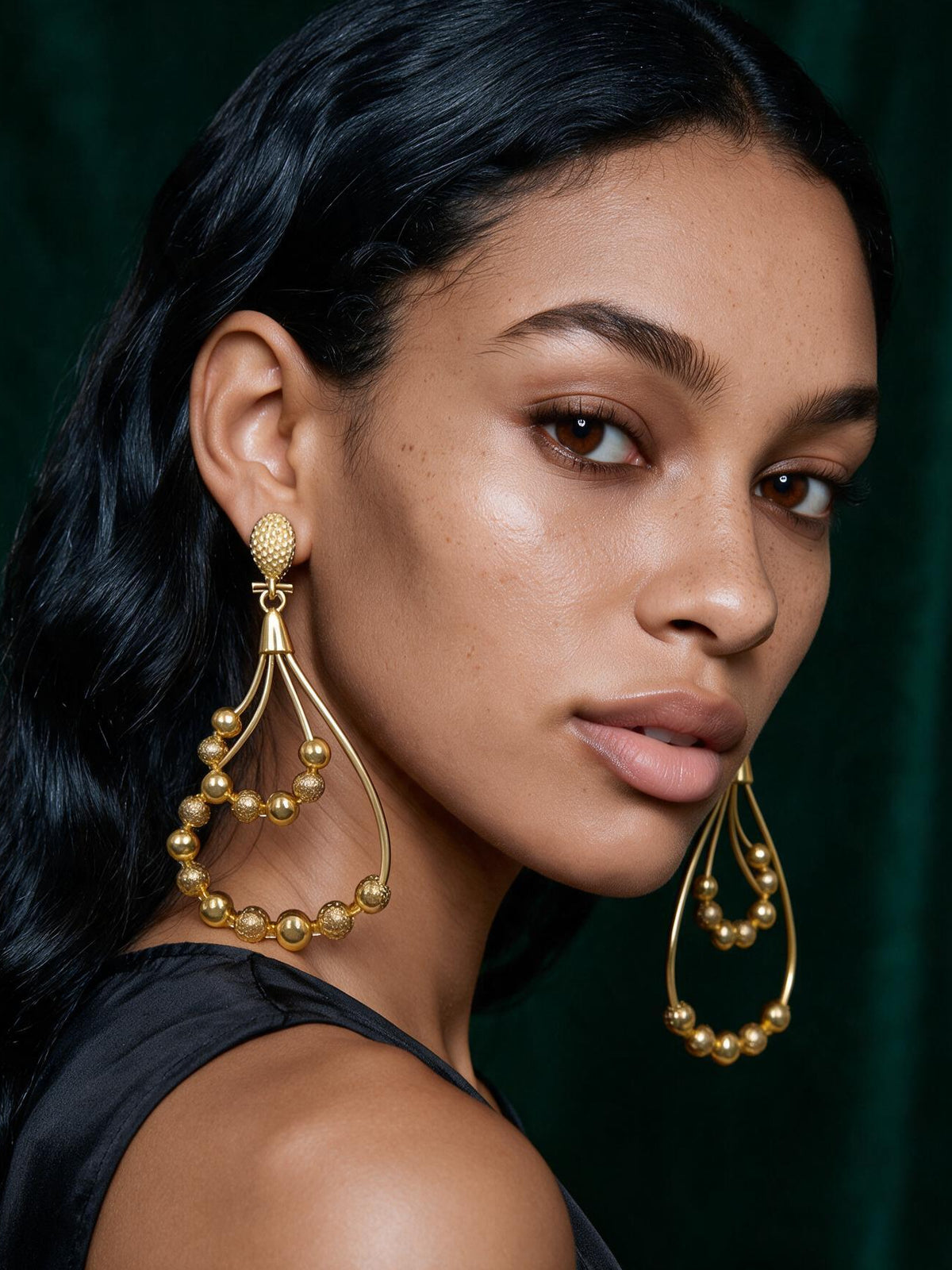 Portrait of a model wearing bold 18K gold plated African statement earrings showcasing elegant movement and lightweight luxury design.