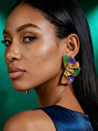 Side view of colorful geometric stud earrings with sculptural ruffle design showcasing purple, green, and gold enamel and lightweight statement construction.