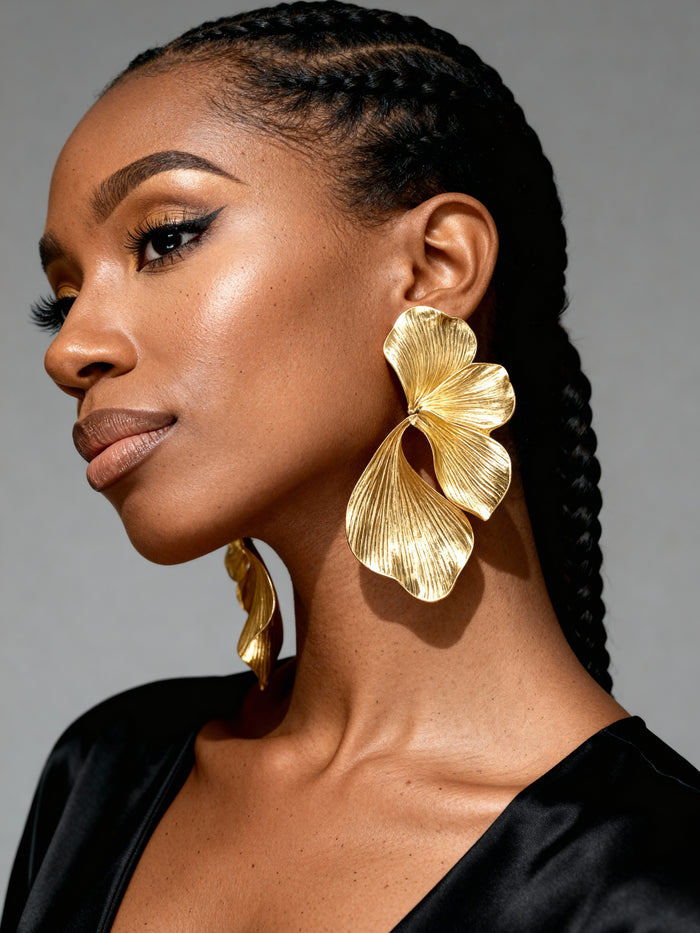 Black Woman wearing oversized gold orchid flower statement earrings with textured botanical petals, styled as elegant lightweight jewelry for statement earrings for vacation outfits, weddings, and special occasions. gold earrings that look designer

This are luxury gold flower earrings, lightweight oversizede for wedding guests and are bold earrings for Black women, who love earrings flower summer dresses
They are high fashion statement elegant earrings under $50,