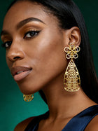 Close-up of lightweight gold filigree statement earrings with floral stud detailing and modern Afro-luxe styling.