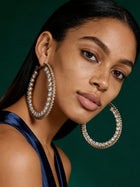 Model wearing oversized rhinestone crystal hoop earrings with sleek hairstyle, glamorous gold statement earrings for wedding guests and parties.