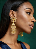 Side profile showcasing elegant African-inspired gold drop earrings with intricate openwork teardrop silhouette.